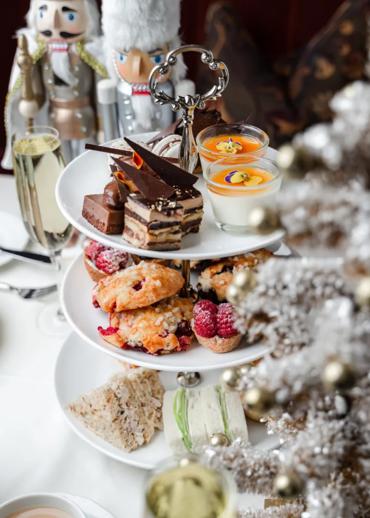 A picture of the afternoon tea at the Wedgewood Hotel in Vancouver. Nutcracker dolls and Christmas decorations surround the three tiered tea tray.